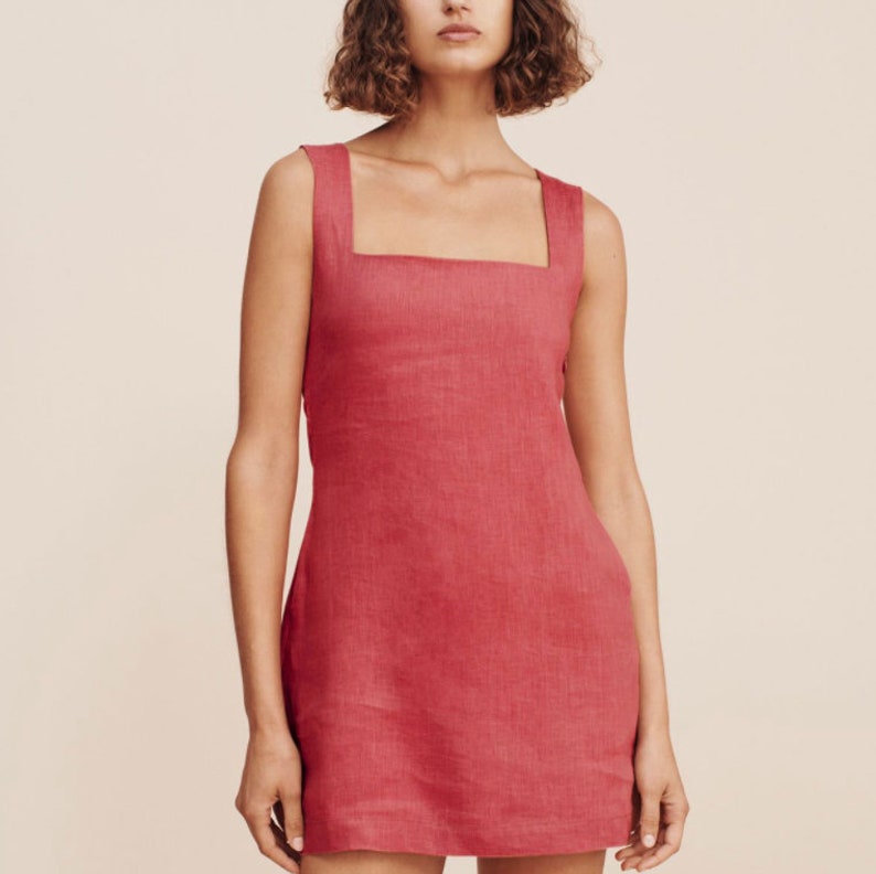 May include: A sleeveless, pink linen dress with a square neckline and a fitted silhouette.