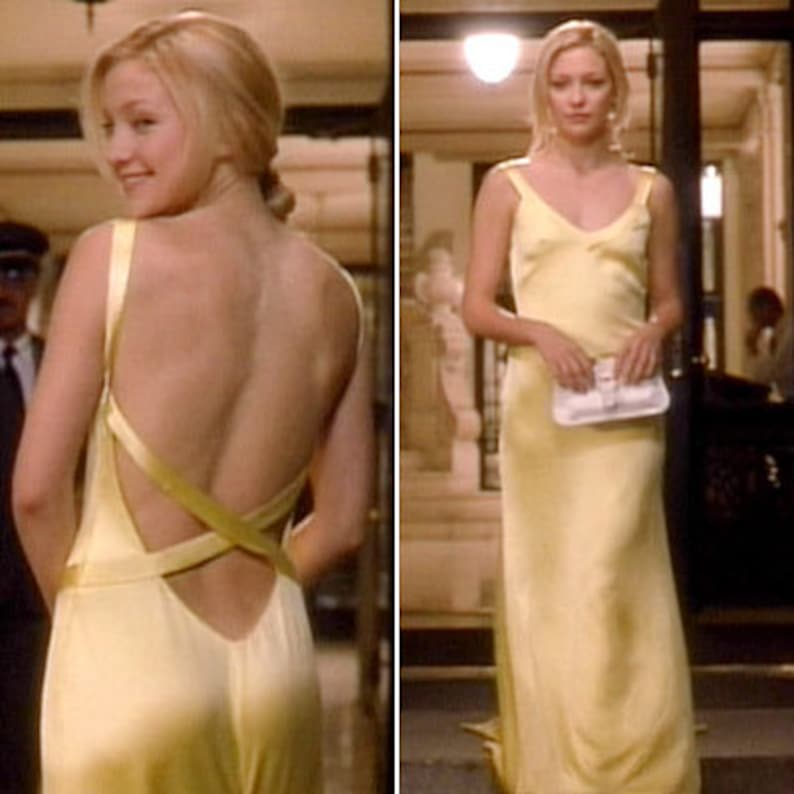 Puede incluir: Una mujer lleva un vestido de sat&eacute;n amarillo con la espalda baja y tirantes que se cruzan en la espalda. El vestido tiene un dise&ntilde;o simple y elegante.