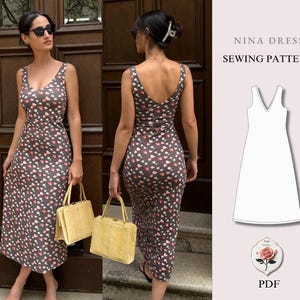May include: A Nina Dress sewing pattern PDF featuring a sleeveless, V-neck midi dress in a dark gray fabric with a small white and pink floral print. The image displays the front and back views of the dress alongside a technical line drawing.