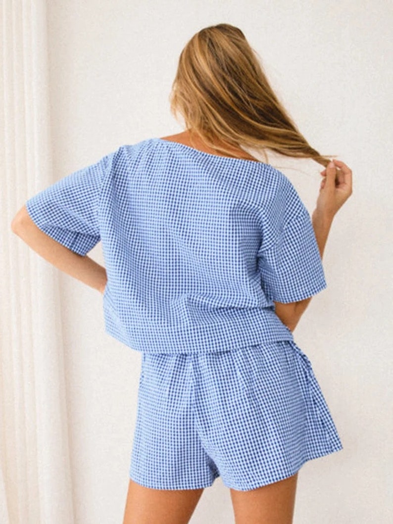 K&ouml;nnte beinhalten: Ein zweiteiliges Set bestehend aus einem kurz&auml;rmeligen Oberteil und einer passenden Shorts, beide mit einem blau-wei&szlig;en Vichy-Karo-Muster. Das Oberteil hat eine lockere, kastige Passform mit weitem Ausschnitt, w&auml;hrend die Shorts locker geschnitten ist.