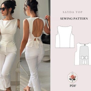 Può includere: Un top bianco con scollatura quadrata e schiena scoperta, abbinato a pantaloni bianchi. Il top ha un dettaglio a fiocco sulla schiena. L'immagine include anche un diagramma del modello di cucito con il testo "SAYDA TOP SEWING PATTERN".