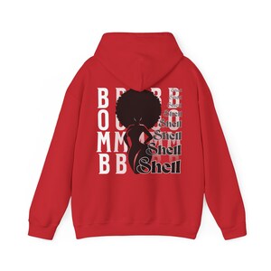 May include: Red hooded sweatshirt with a black silhouette of a woman with an afro and the text "BOOM" and "Shell" repeated in white.