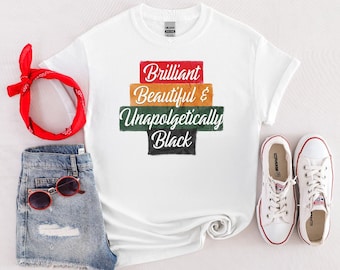 Puede incluir: Camiseta blanca con el texto "Brilliant, Beautiful & Unapologetically Black" en un diseño apilado. La imagen también incluye pantalones cortos de mezclilla, gafas de sol rojas, una bandana roja y zapatillas blancas.