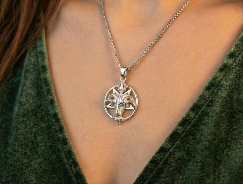 A silver pendant necklace with a circular design on the front.