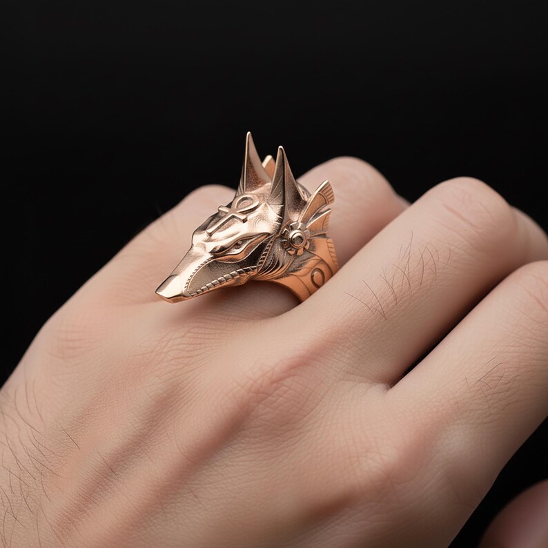 A close-up image of a person's hand wearing a gold-colored ring featuring a detailed design of a fox's head.