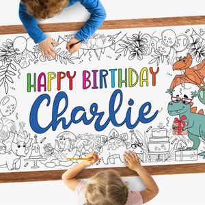 May include: A white coloring poster with a dinosaur theme. The poster says "Happy Birthday Charlie" in colorful letters. The poster has outlines of dinosaurs, plants, and other birthday party decorations that can be colored in.