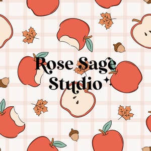 Puede incluir: Patrón repetitivo con manzanas rojas, algunas mordidas, con hojas verdes, bellotas y hojas de otoño sobre un fondo de cuadros rosa claro. El texto "Rose Sage Studio" está en el centro.