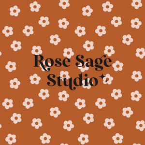 Op de afbeelding: Een bruine achtergrond met een wit bloemenpatroon. De tekst "Rose Sage Studio" staat in het midden van de afbeelding.