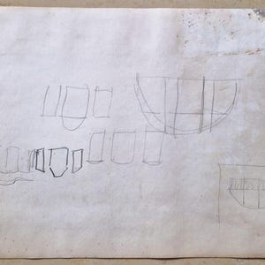 Puede incluir: Un boceto dibujado a mano en papel blanco con varias formas geom&eacute;tricas, incluyendo rect&aacute;ngulos, cuadrados y una forma curva que se asemeja a un barco.