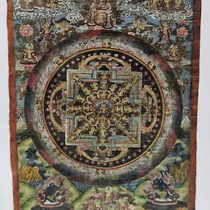 Pu&ograve; includere: Un dipinto di mandala colorato su carta con un quadrato centrale circondato da un cerchio di quadrati pi&ugrave; piccoli. Il mandala &egrave; circondato da un bordo di fiori e foglie. Il dipinto &egrave; in stile tradizionale tibetano.