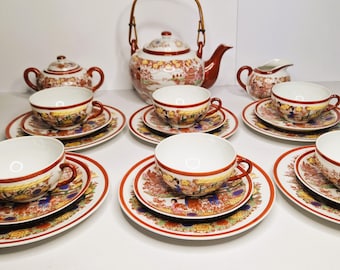 May include: A vintage Japanese tea set with a floral design. The set includes a teapot, sugar bowl, creamer, and six teacups and saucers.