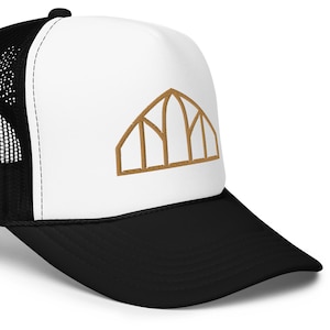 May include: A white and black trucker hat with a brown embroidered design of an arched window with multiple panes.