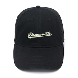 May include: A black baseball cap with a white embroidered logo that says "Dreamville".