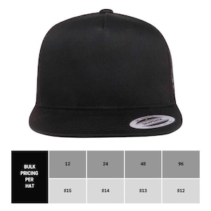 May include: A black trucker hat with a mesh back. The hat has a flat brim and a structured crown. The hat is blank and ready for customization.