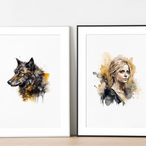 Pode incluir: Duas pinturas de aquarela emolduradas. A pintura da esquerda apresenta um lobo preto e marrom com respingos de aquarela amarela. A pintura da direita apresenta uma mulher com cabelo loiro e uma camisa preta com respingos de aquarela amarela.