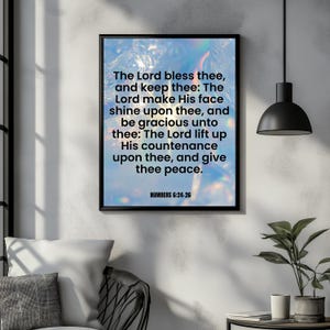 May include: A framed print with a black border displays a religious quote against a blue and white background. The text reads, "The Lord bless thee...and give thee peace." The bottom of the print reads "NUMBERS 6:24-26."