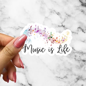 May include: A white sticker with a rainbow-colored musical note design and the text "Music is Life".