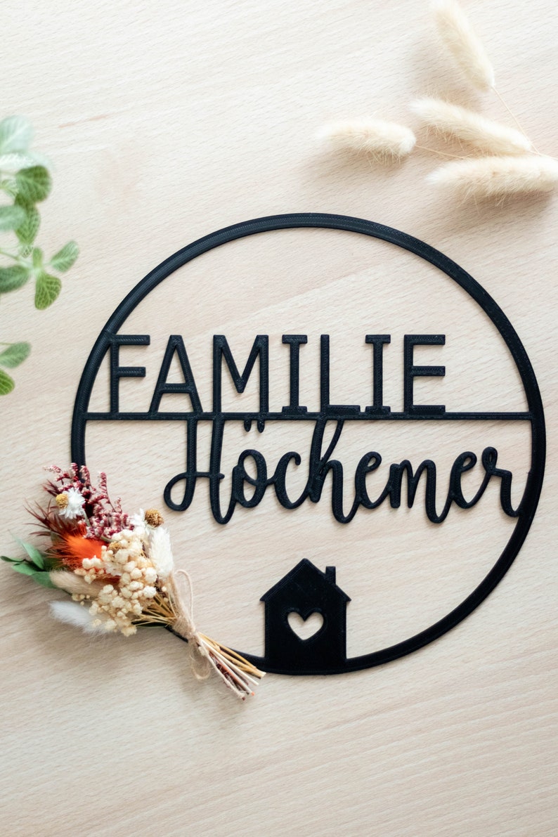 Personalisiertes 3D gedrucktes Türschild mit Familienname, schwarzer moderner Schriftzug im Kreis, dekoriert mit Trockenblumen, minimalistische Haustür Deko