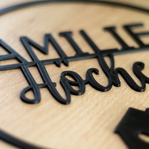 Detailansicht eines personalisierten Türschilds aus nachhaltigem 3D Druck Material mit Familiennamen, moderne schwarze Typografie