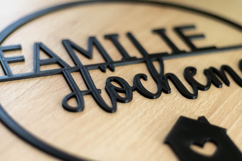 Detailansicht eines personalisierten Türschilds aus nachhaltigem 3D Druck Material mit Familiennamen, moderne schwarze Typografie