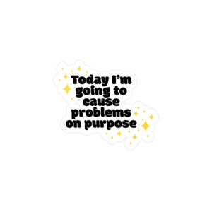 May include: A white sticker with a black and yellow design. The text on the sticker reads "Today I'm going to cause problems on purpose".