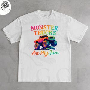 May include: White t-shirt featuring a colorful graphic of a monster truck. The text "MONSTER TRUCKS Are My Jam" is displayed above and below the truck illustration. The truck is orange with blue and yellow wheels.