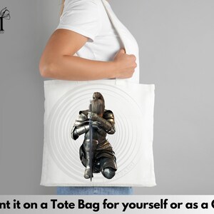 Puede incluir: Un bolso tote blanco con un estampado gr&aacute;fico de un caballero con armadura met&aacute;lica completa arrodillado mientras sostiene una espada larga en posici&oacute;n vertical. El caballero est&aacute; situado frente a un patr&oacute;n circular gris. Tiene dos asas.