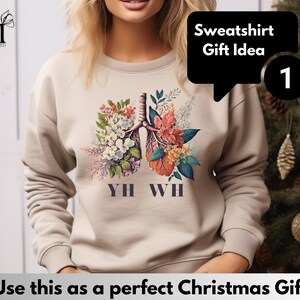 May include: Beige sweatshirt with a floral design of lungs and the text "YH WH". The sweatshirt is a gift idea.