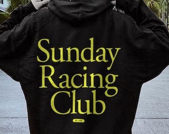 Puede incluir: Sudadera con capucha negra con el texto "Sunday Racing Club" en letras amarillas en la parte posterior.