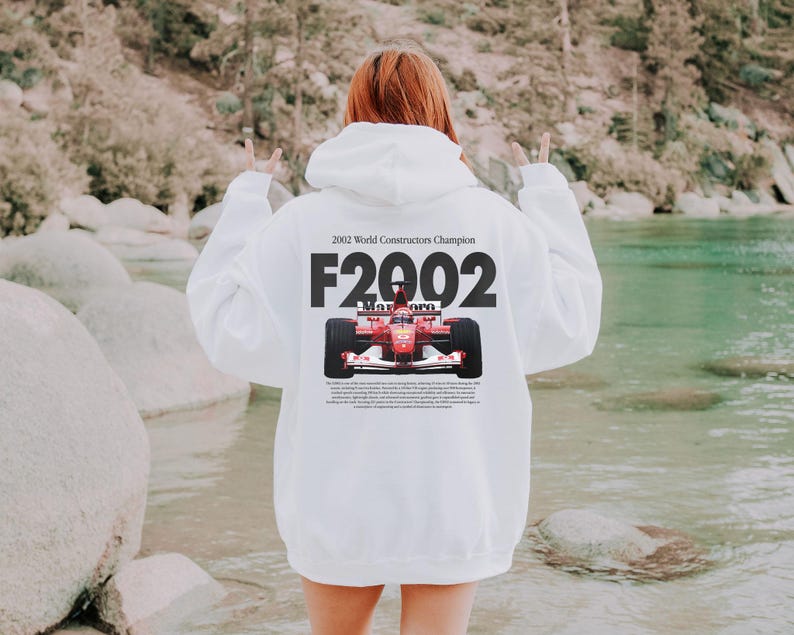 May include: White hooded sweatshirt with a red race car graphic and the text "2002 World Constructor Champion F2002".