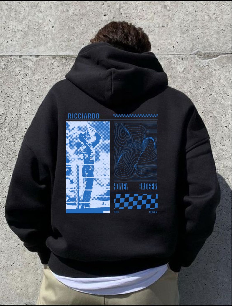 May include: Black hooded sweatshirt with a blue graphic print featuring a racing driver, a chequered flag, and the text "RICCIARDO HONEY BADGER PERTH AUSTRALIA".