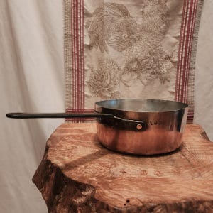 24 cm-9,5 tum i diameter, antik kopparkastrull med smidesjärnshandtag och ny tennfoder; antik kopparkastrull med ägarstämpel, 2 mm vid kanten, 1,8 kg