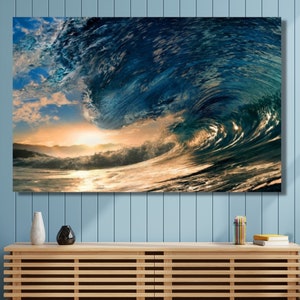 Może przedstawiać: Duża fala rozbijająca się w oceanie o zachodzie słońca. Fala jest ciemnoniebieska z białą pianą na szczycie. Słońce zachodzi za falą, rzucając złote światło na wodę.