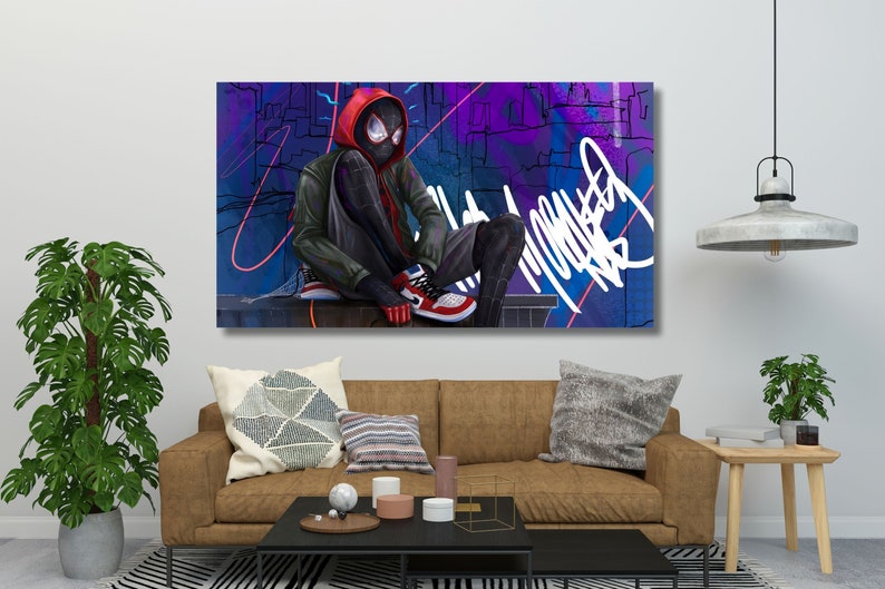 May include: A digital art print featuring a superhero in a black and red suit sitting on a ledge against a colourful graffiti background. The superhero is wearing a red hooded jacket and black mask. The background features a cityscape with purple, blue, and pink accents.
