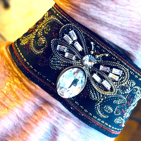 Bracelet with Black Jacquard Fabric Enhanced in Gold and Burgundy Trim with Beautiful Butterfly Pendant and a Rhinestone Magnetic Closure