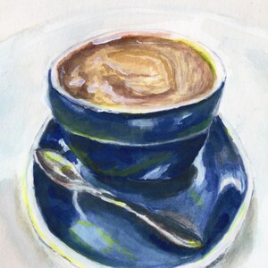 Pu&ograve; includere: Una tazza da caff&egrave; in ceramica blu con un piattino, piena di caff&egrave;. Il caff&egrave; ha un colore marrone chiaro e un motivo a spirale in cima.