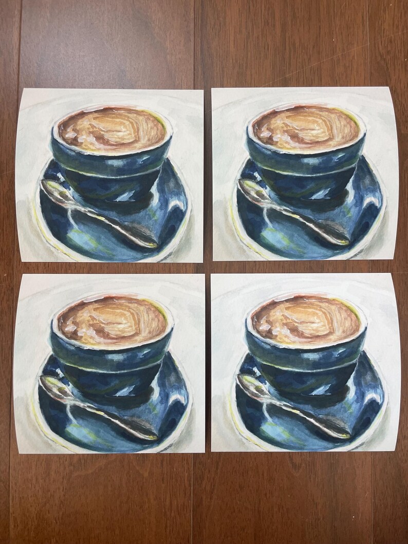 Pu&ograve; includere: Quattro dipinti di una tazza di caff&egrave; blu con una bevanda al caff&egrave; marrone all'interno. Ogni dipinto ha uno sfondo bianco e un piattino blu con un cucchiaio d'argento.