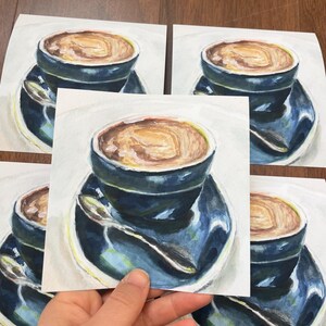 Pu&ograve; includere: Quattro acquerelli di una tazza di caff&egrave; con un piattino e un cucchiaio. Il caff&egrave; &egrave; di colore marrone chiaro e la tazza e il piattino sono di colore blu scuro.