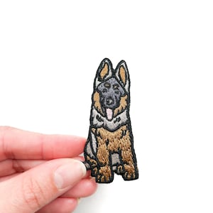 以下が含まれることがあります： 座って舌を出している茶色と黒のジャーマンシェパードの刺繍アイロン接着パッチ