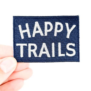 Patch termocolante bordado "Happy Trails" em azul marinho e branco. Perfeito para equipamentos de caminhada, mochilas, jaquetas e para amantes da natureza e aventuras ao ar livre.