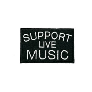 Puede incluir: Un parche rectangular negro con texto bordado en blanco que dice "SUPPORT LIVE MUSIC". El parche está diseñado para ser cosido o planchado en ropa o accesorios, promoviendo la música en vivo.