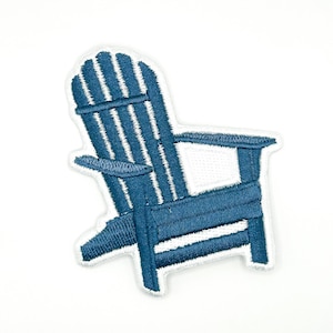 May include: An embroidered patch in the shape of an Adirondack chair. The chair is rendered in a deep blue thread with white stitching details, featuring a high slatted back, wide armrests, and a low seat, finished with a white border edge.