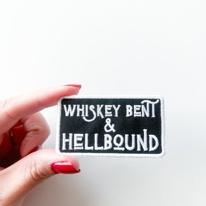 以下が含まれることがあります： 黒地に「Whiskey Bent & Hellbound」という文字が白で刺繍されたパッチ