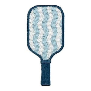 May include: An embroidered patch shaped like a pickleball paddle. The paddle face features a vertical wavy pattern in alternating light blue and white thread. The handle and the outer border of the paddle are stitched in a solid dark blue thread.