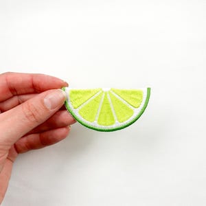 May include: A green and yellow embroidered lime wedge patch. The lime wedge is a popular motif for summer and tropical themes.