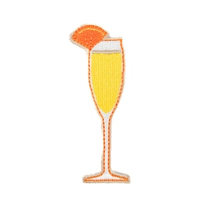 May include: Embroidered patch of a mimosa cocktail in a champagne flute. The drink is yellow with a white foam top and an orange slice garnish. The patch has an orange outline and is on a white background.