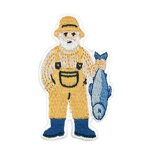May include: An embroidered patch featuring a bearded figure wearing a yellow hat, a beige sweater, and yellow overalls. The figure is holding a large blue fish in one hand and is wearing dark blue boots. The patch has a white border outline.