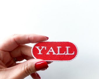 May include: Red oval-shaped patch with white embroidered text that reads "Y'ALL".