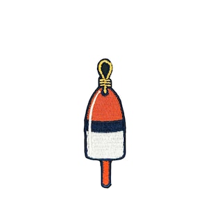 May include: Embroidered patch of a red, white, and navy blue buoy with a yellow loop at the top. The buoy has a rounded top and a rectangular bottom with a small, orange stem. The patch is on a white background.