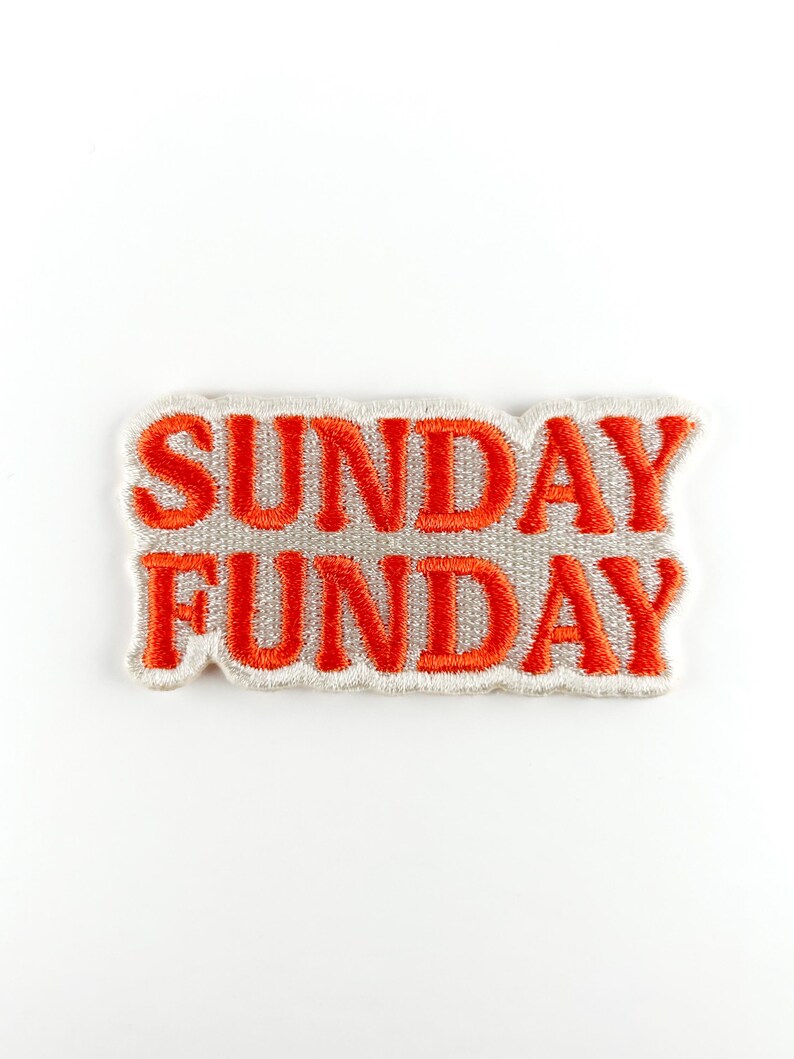 Puede incluir: Parche bordado con las palabras "SUNDAY FUNDAY" en hilo naranja brillante. El texto est&aacute; cosido sobre una tela gris claro con un borde blanco, perfecto para a&ntilde;adir a ropa o accesorios.